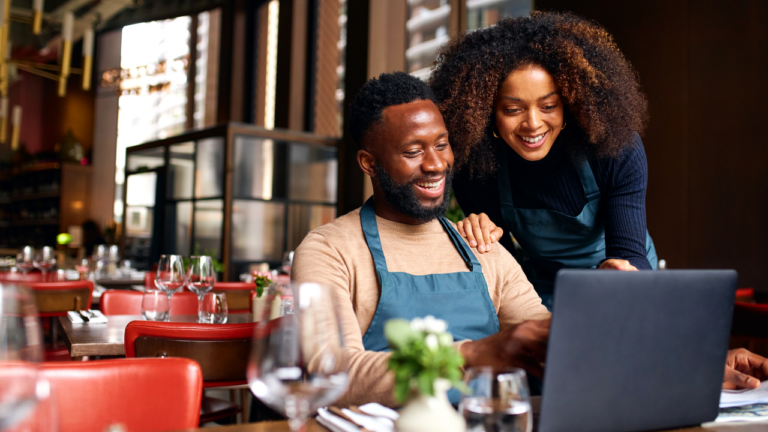 Black couple working on a laptop in restaurant